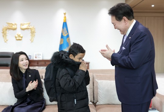캄보디아 소년 옥 로타 군이 31일 서울 용산 대통령실 청사에서 윤석열 대통령으로부터 학용품 등이 담긴 책가방을 선물받고 감사인사를 전하고 있다. 대통령실 제공